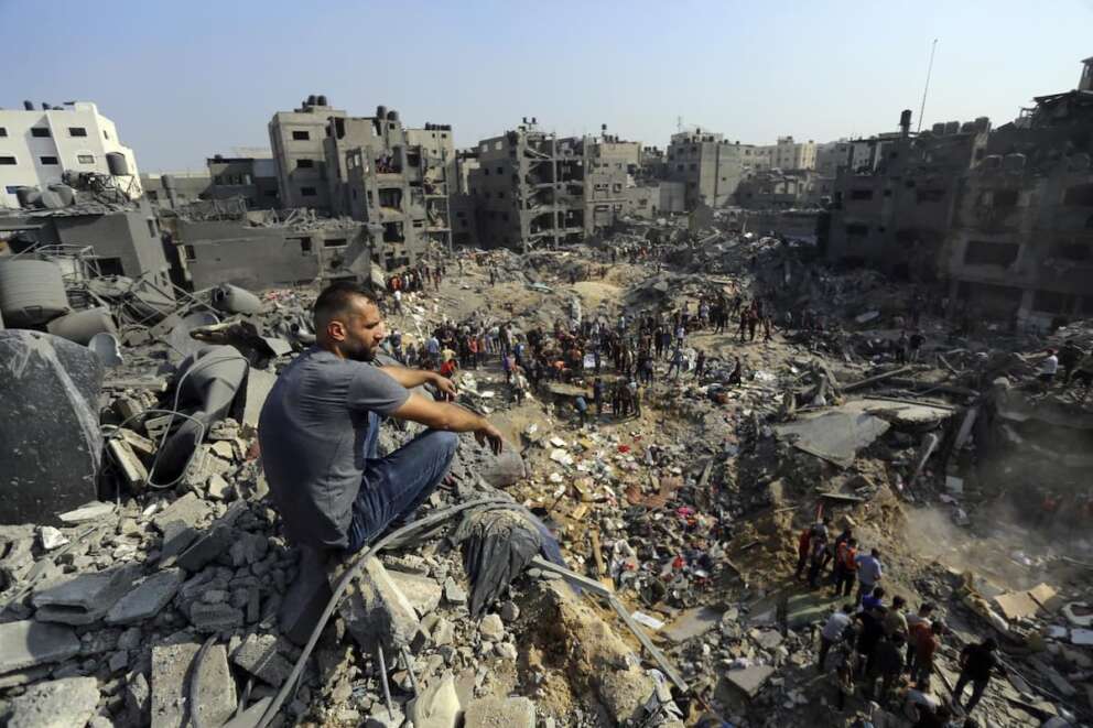A man sits on the rubble overlooking the debris of buildings that were targeted by Israeli airstrikes in the Jabaliya refugee camp, northern Gaza Strip, Wednesday, Nov. 1, 2023. (AP Photo/Abed Khaled)
