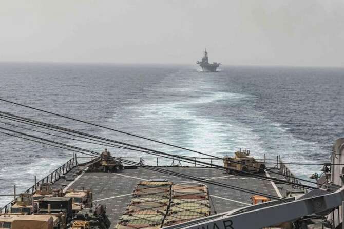 In this image provided by the U.S. Navy, the amphibious dock landing ship USS Carter Hall and amphibious assault ship USS Bataan transit the Bab al-Mandeb strait on Aug. 9, 2023. The top commander of U.S. naval forces in the Middle East says Yemen’s Houthi rebels are showing no signs of ending their “reckless” attacks on commercial ships in the Red Sea. But Vice Adm. Brad Cooper said in an Associated Press interview on Saturday that more nations are joining the international maritime mission to protect vessels in the vital waterway and trade traffic is beginning to pick up. (Mass Communications Spc. 2nd Class Moises Sandoval/U.S. Navy via AP)