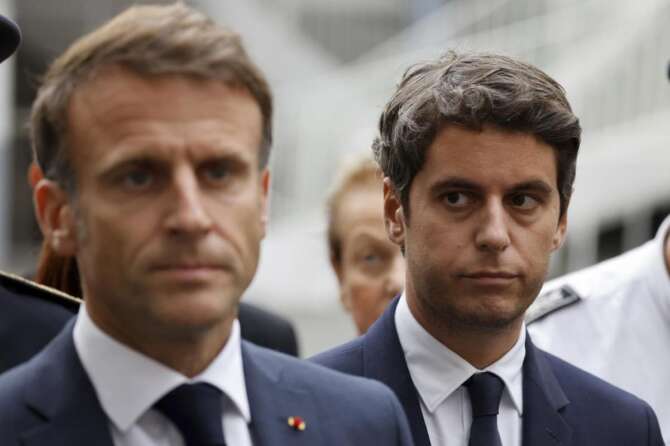 FILE – Then French Education and Youth Minister Gabriel Attal watches French President Emmanuel Macron talking to the press at the Gambetta high school in Arras, northeastern France, Friday Oct. 13, 2023. Gabriel Attal was named Tuesday Jan.9, 2024 as France’s youngest-ever prime minister, as President Emmanuel Macron seeks a fresh start for the rest of his term amid growing political pressure from the far right. (Ludovic Marin, Pool via AP, File)