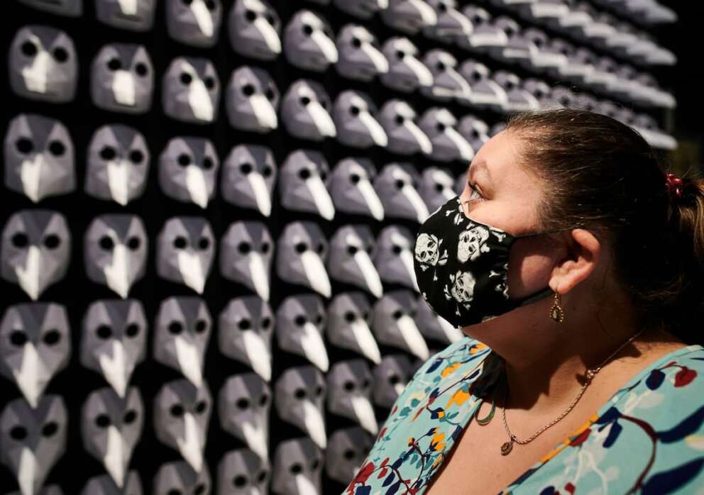 Ingrid Cosic, wearing a face mask with a skull pattern as she stands in front of an exhibit of 300 so-called plague masks, which were worn by doctors in the middle ages to protect against infection with the plague at the exhibition ‘Plague – A Search for Clues at the LWL Museum of Archaeology in Herdecke, Germany, Tuesday, May 5, 2020. The special exhibition on the plague has been extended until 15 November because of the coronavirus outbreak and the closing of the museum. (Bernd Thissen/dpa via AP)