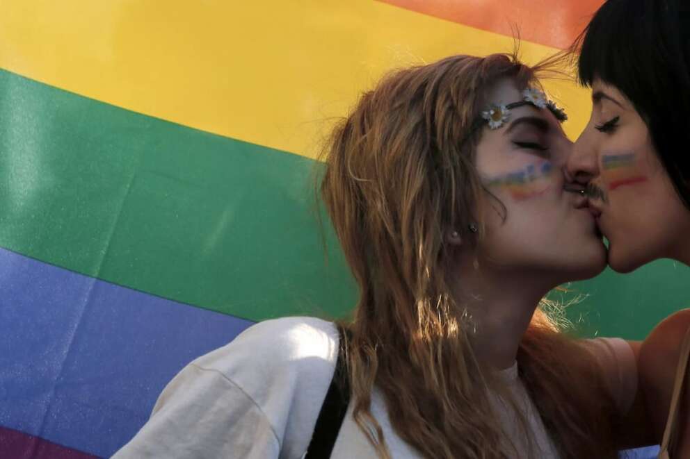 FILE – In this Saturday, June 14, 2014 file photo, two women kiss in front of a rainbow flag, the symbol of the gay rights movement, during the Gay Pride parade in central Athens. Around the globe, LGBT Pride Month has been marked with parades and marches, festivals and dances, and in some cases, protests and counter-protests. (AP Photo/Petros Giannakouris, File) Associated Press/LaPresse Only Italy and Spain