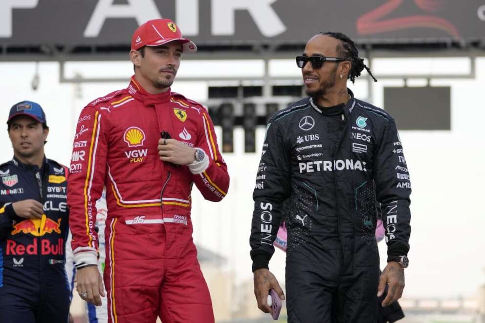 Ferrari driver Charles Leclerc of Monaco, second left, speaks with Mercedes driver Lewis Hamilton of Britain as they arrive for the Formula One Bahrain Grand Prix at the Bahrain International Circuit in Sakhir, Bahrain, Saturday, March 2, 2024. (AP Photo/Darko Bandic)