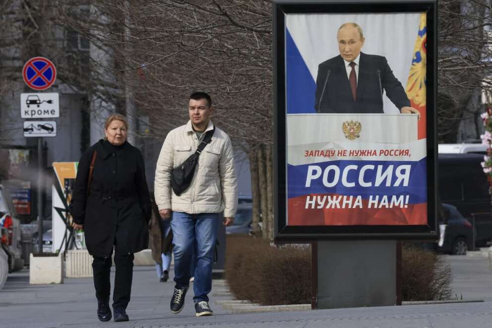 People walk past a billboard with an image of Russian President Vladimir Putin and words reading “The West doesn’t need Russia, we need Russia!” in a street in Sevastopol, Crimea, Wednesday, March 6, 2024. The economy’s resilience in the face of bruising Western sanctions is a major factor behind President Vladimir Putin’s grip on power in Russia. (AP Photo) Associated Press/LaPresse Only Italy and Spain