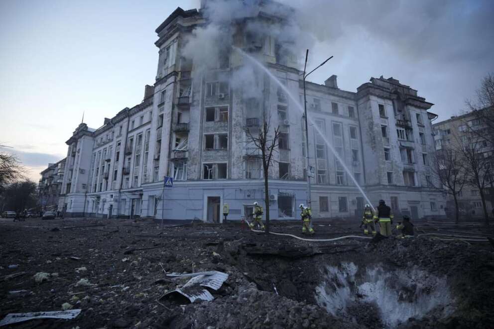 Firefighters work near the crater at the site after Russian attacks in Kyiv, Ukraine, Thursday, March 21, 2024. (AP Photo/Vadim Ghirda)