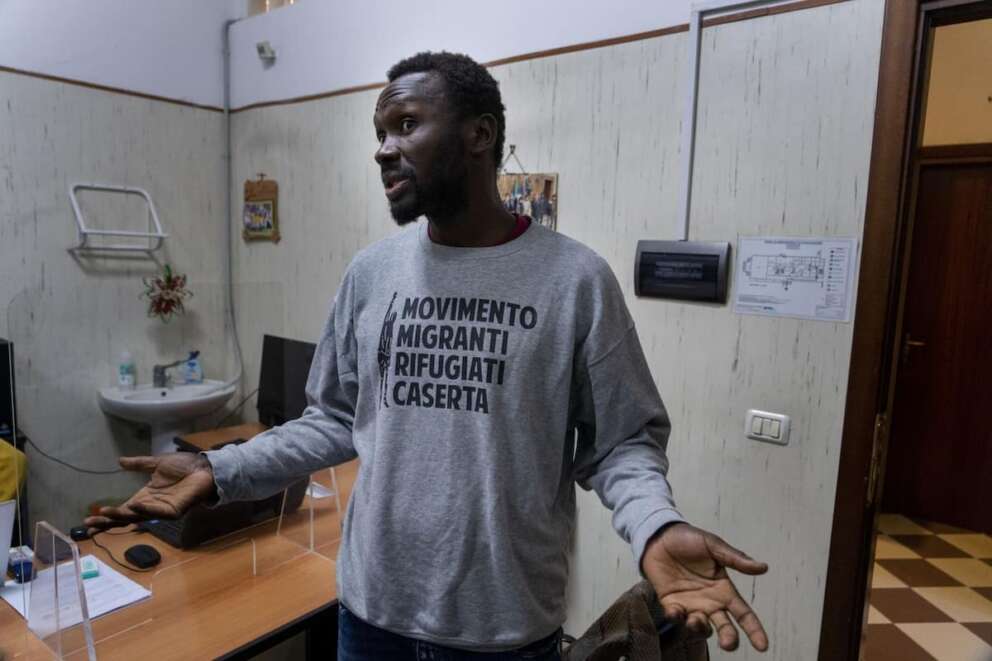 Mamadou Kouassi, left, a migrant who made the journey from his native Ivory Coast to Italy in 2006, talks to The Associated Press during an interview in a migrant center in Castel Volturno, southern Italy, where he now dedicates his life to working with migrants, Thursday, Feb. 1, 2024. Kouassi’s odyssey through Africa inspired the movie Io Capitano (Me Captain) to Italian director Matteo Garrone and is among the nominees for the 2024 96th Academy Awards in the International Feature Film category. (AP Photo/Domenico Stinellis)