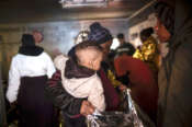 Un bambino appena salvato da un gommone alla deriva in braccio alla sua mamma