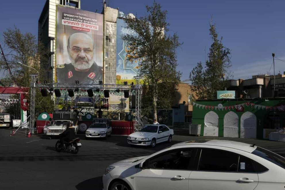 Vehicles drive past a banner showing a portrait of the late Iranian Revolutionary Guard Gen. Mohammad Reza Zahedi who was killed in an airstrike widely attributed to Israel on Monday in Syria, on a building at the Felestin (Palestine) Sq. in downtown Tehran, Iran, Wednesday, April 3, 2024. The sign in Hebrew reads a quotation of Iranian Supreme Leader: “You will be punished by our brave people and we are making you regret.” (AP Photo/Vahid Salemi)