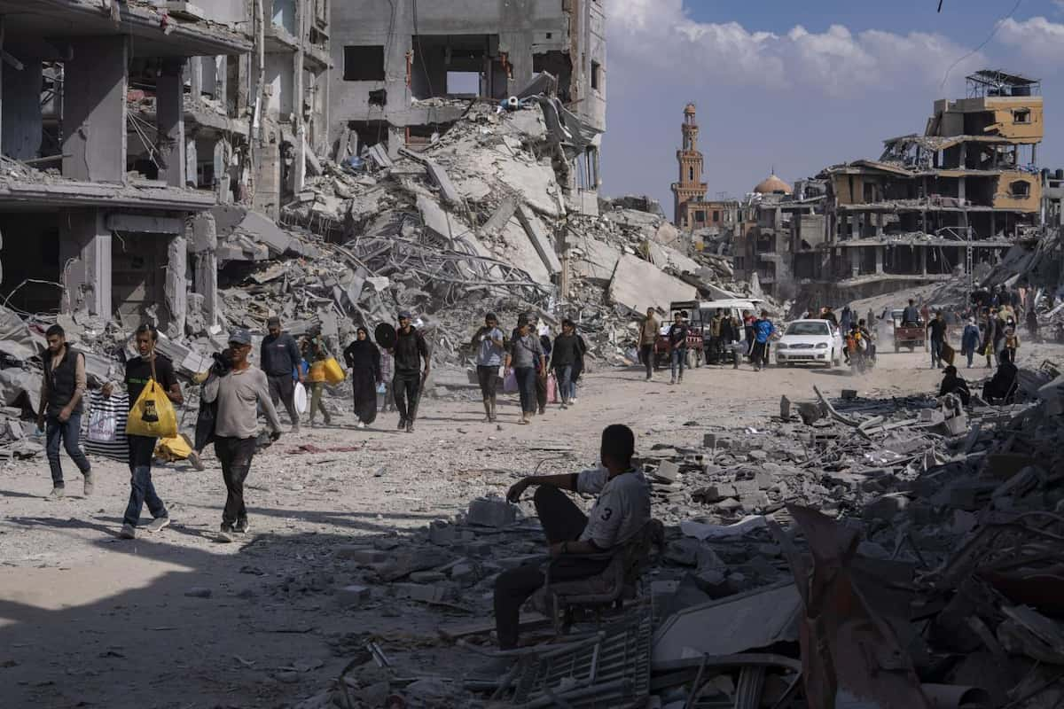 Palestinians walk through the destruction in the wake of an Israeli air and ground offensive in Khan Younis, southern Gaza Strip, Monday, April 8, 2024. Israel says it has withdrawn its last ground troops from the city, ending a four-month operation. (AP Photo/Fatima Shbair)
