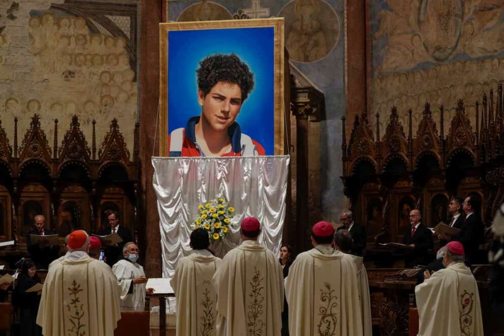 An image of 15-year-old Carlo Acutis, an Italian boy who died in 2006 of leukemia, is unveiled during his beatification ceremony celebrated by Cardinal Agostino Vallini in the St. Francis Basilica, in Assisi, Italy, Saturday, Oct. 10, 2020. (AP Photo/Gregorio Borgia)