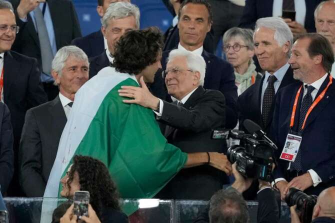 Gianmarco Tamberi, of Italy, climbs the tribune and speaks with Italian President Sergio Mattarella after winning the gold medal in the men’s high jump final at the European Athletics Championships in Rome, Tuesday, June 11, 2024. (AP Photo/Andrew Medichini)