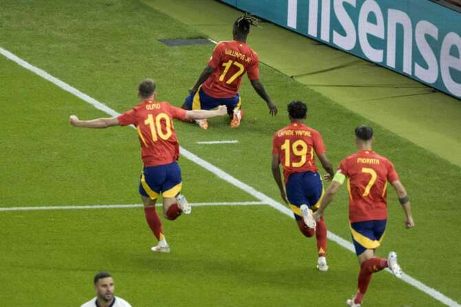 Spain’s Nico Williams, top, celebrates after scoring the opening goal against England during the final match at the Euro 2024 soccer tournament in Berlin, Germany, Sunday, July 14, 2024. (AP Photo/Thanassis Stavrakis)