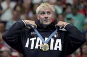 Gold medalist Nicolo Martinenghi reacts on the podium after winning the men’s 100-meter breaststroke final at the 2024 Summer Olympics, Sunday, July 28, 2024, in Nanterre, France. (AP Photo/Matthias Schrader)