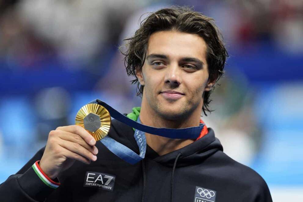 Gold medalist Thomas Ceccon, of Italy, poses on the podium after the men’s 100-meter backstroke final at the 2024 Summer Olympics, Monday, July 29, 2024, in Nanterre, France. (AP Photo/Martin Meissner)