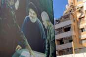 A poster showing the late Hezbollah military commander Imad Mughniyeh, left, Hezbollah leader Sayyed Hassan Nasrallah, center, and the late Revolutionary Guard Gen. Qassem Soleimani is set near a damaged building that was hit by an Israeli airstrike on Tuesday evening in the southern suburbs of Beirut, Lebanon, Wednesday, July 31, 2024. Israel on Tuesday carried out a rare strike on Beirut, which it said killed a top Hezbollah commander who was allegedly behind a weekend rocket attack that killed 12 young people in the Israeli-controlled Golan Heights. (AP Photo/Hussein Malla) Associated Press / LaPresse Only italy and Spain