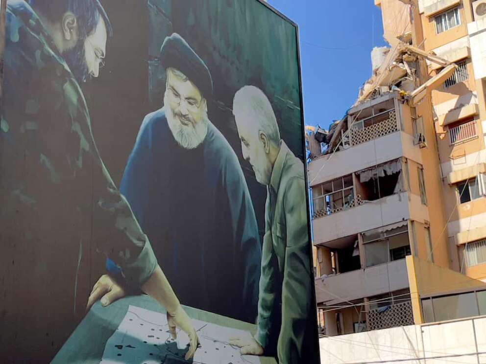 A poster showing the late Hezbollah military commander Imad Mughniyeh, left, Hezbollah leader Sayyed Hassan Nasrallah, center, and the late Revolutionary Guard Gen. Qassem Soleimani is set near a damaged building that was hit by an Israeli airstrike on Tuesday evening in the southern suburbs of Beirut, Lebanon, Wednesday, July 31, 2024. Israel on Tuesday carried out a rare strike on Beirut, which it said killed a top Hezbollah commander who was allegedly behind a weekend rocket attack that killed 12 young people in the Israeli-controlled Golan Heights. (AP Photo/Hussein Malla) Associated Press / LaPresse Only italy and Spain