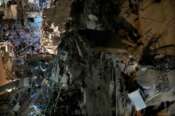 Civil defence workers gather at the wreckage of a destroyed building that was hit by an Israeli airstrike in the southern suburbs of Beirut, Lebanon, Tuesday, July 30, 2024. An Israeli airstrike hit Hezbollah’s stronghold south of Beirut Tuesday evening causing damage, a Hezbollah official and the group’s TV station said. (AP Photo/Hussein Malla)