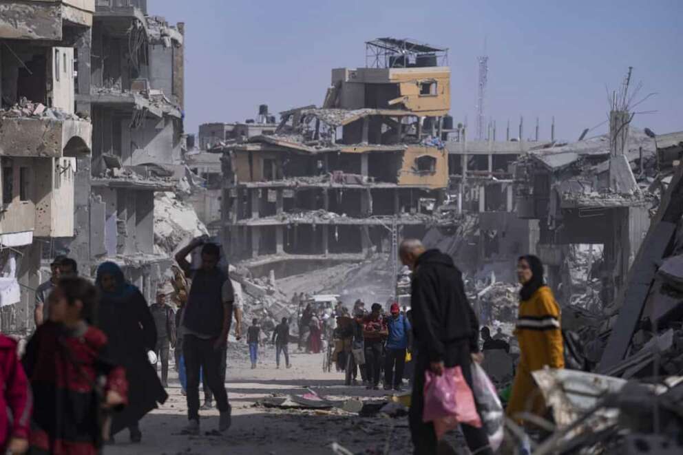 Palestinians walk through the destruction in the wake of an Israeli air and ground offensive in Khan Younis, southern Gaza Strip, Monday, April 8, 2024. Israel says it has withdrawn its last ground troops from the city, ending a four-month operation. (AP Photo/Fatima Shbair)