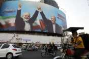 Vehicles drive past a huge banner showing the late Hamas leader Ismail Haniyeh, left, who was killed in an assassination last week, joining hands with Iranian President Masoud Pezeshkian, in a square in downtown Tehran, Iran, Monday, Aug. 5, 2024. Iran has vowed to respond with “power and decisiveness” to the targeted killing of Hamas’ top political leader, which it blamed on Israel. (AP Photo/Vahid Salemi) Associated Press / LaPresse Only italy and Spain