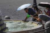 People try to get some relief cooling off at a fountain as temperatures are reaching up to 39 degrees Celsius (102.20 Fahrenheit) in Rome, Monday, July 29, 2024. (AP Photo/Gregorio Borgia) Associated Press/LaPresse