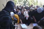 Evacuated people in the Kursk region queue to fill out the form for humanitarian aid at a humanitarian aid distribution center in Kursk, Russia, Wednesday, Aug. 14, 2024. (AP Photo)