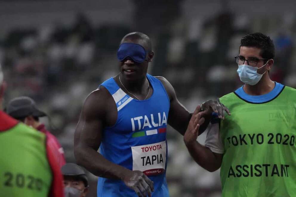 Oney Tapia of Italy prepares to compete with an assistant in the men’s shot put F11 final during the Tokyo 2020 Paralympics Games at the National Stadium in Tokyo, Japan, Monday, Aug. 30, 2021. (AP Photo/Eugene Hoshiko)