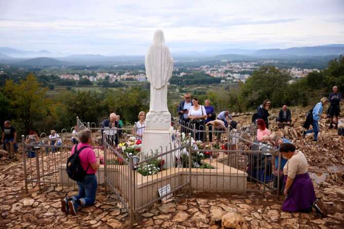 Pilgrims pray next to the statue of Virgin Mary on the Hill of appearance where it is believed that Virgin Mary showed herself and conveyed messages of peace to six children in Medjugorje, Bosnia, Thursday, Sept. 19, 2024. (AP Photo/Armin Durgut) Associated Press / LaPresse Only italy and Spain