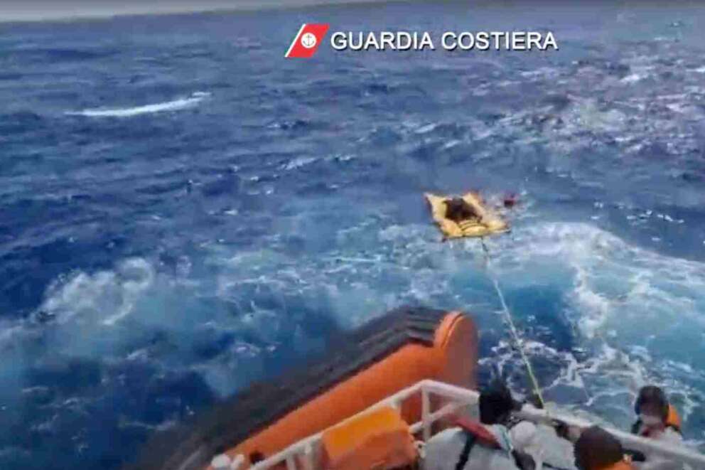 The image made from a video provided by the Italian coast guard shows a patrol boat rescuing migrants from a sinking ship off the coast of Lampedusa, Italy