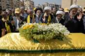 Senior Hezbollah leader Hashem Safieddine, center, prays over the coffin of senior commander Taleb Sami Abdullah, 55, known within Hezbollah as Hajj Abu Taleb, who was killed late Tuesday by an Israeli strike in south Lebanon, during his funeral procession in the southern suburbs of Beirut, Lebanon, Wednesday, June 12, 2024. Hezbollah fired a massive barrage of rockets into northern Israel on Wednesday to avenge the killing of the top commander in the Lebanese militant group as the fate of an internationally-backed plan for a cease-fire in Gaza hung in the balance. (AP Photo/Bilal Hussein)