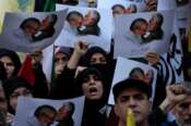 Iranian demonstrators chant slogans as they hold posters showing the late Iranian Revolutionary Guard Gen. Qassem Soleimani, who was killed in Iraq in a U.S. drone attack in 2020, kissing forehead of slain Hezbollah leader Hassan Nasrallah in an anti-Israeli gathering at Felestin (Palestine) Square in Tehran, Iran, Tuesday, Oct. 8, 2024. (AP Photo/Vahid Salemi)