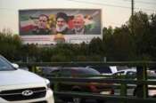 Vehicles drive past a billboard on a highway in Tehran, Iran, Monday, Oct. 7, 2024, showing slain Hezbollah leader Hassan Nasrallah, center, late Hamas leader Ismail Haniyeh, right, and the late Iranian Revolutionary Guard Gen. Abbas Nilforushan, who was killed in an Israeli airstrike. The billboard contains a verse of Quran that reads: “We will surely inflict punishment upon the wicked.” (AP Photo/Vahid Salemi)