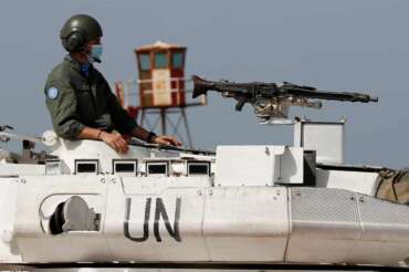 FILE – An Italian U.N. peacekeeping soldier sits on a tank at a road that links to a UNIFIL base where the Lebanese and Israeli delegations meet, in Naqoura town, Lebanon, Tuesday, May 4, 2021. Lebanon and Israel resumed Tuesday indirect talks over their disputed maritime border with U.S. mediation after nearly a six-month pause that saw a new American administration take over.(AP Photo/Hussein Malla)