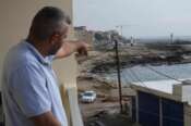 A Lebanese man points to the beach in Batroun, northern Lebanon, Saturday, Nov. 2, 2024, where Lebanese officials say a group of armed men landed on a coast north of Beirut and took away a ship captain and they\’re investigating whether Israel was involved. (AP Photo/Hussein Malla)