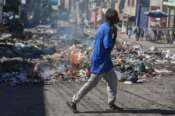 A man walks past burning garbage in downtown Port-au-Prince, Haiti, Monday, Dec. 9, 2024. (AP Photo/Odelyn Joseph) Associated Press / LaPresse Only italy and Spain