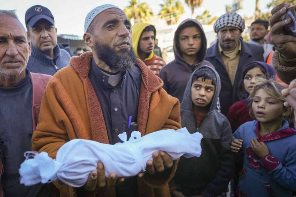 Imam Islam Abu Suaied holds the body of 20-day-old Jomaa al-Batran , who died from hypothermia, before the funeral at Al-Aqsa Martyrs Hospital in central Gaza, Sunday, Dec. 29, 2024. Jomaa’s twin brother, Ali, remains in intensive care, as local health officials report at least three other infant deaths from the cold in recent weeks. (AP Photo/Abdel Kareem Hana) Associated Press/LaPresse