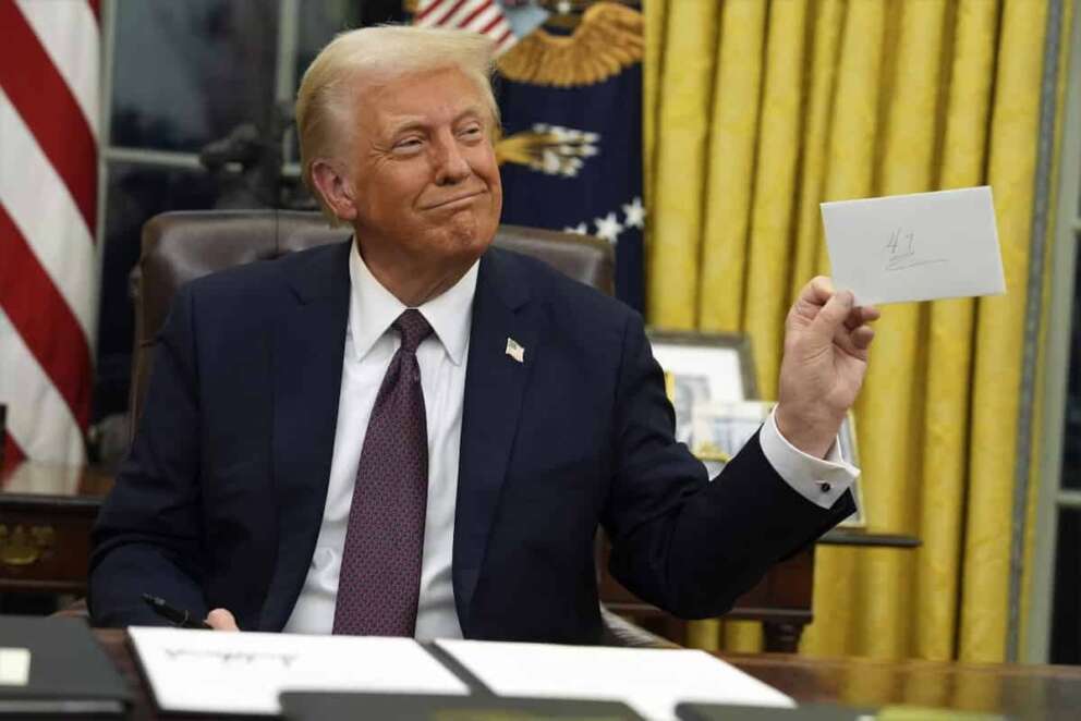 President Donald Trump holds up the letter that former President Joe Biden left for him in the desk as he signs executive orders in the Oval Office of the White House, Monday, Jan. 20, 2025, in Washington. (AP Photo/Evan Vucci) Associated Press/LaPresse